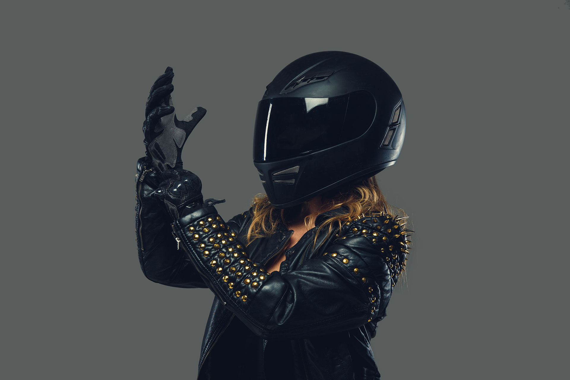 female-in-leather-clothes-moto-gloves-and-safety-helmet-on-grey-background